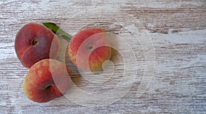 Top view on ripe juicy saturn peach on a wooden background