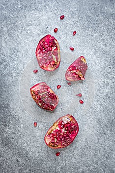 Top view of ripped pomegranate fruit over grey stone background