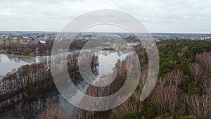 Top view of the river. Dry trees on the banks. In the background of the house. Poland