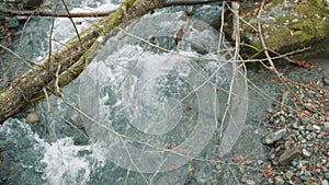 Top view of river waterfall with foaming clear water in autumn dull forest