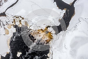 Top view of the river waterfall. Winter aerial view of a freezing river.