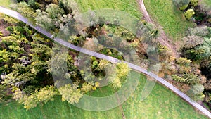 Top view of road in forest and green fields