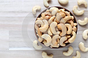 Top view of Roasted cashew nuts in a bowl on wooder background, Healthy eating concept