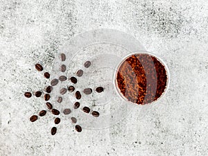 Top view of roasted coffee beans in sun shape with defocused powder