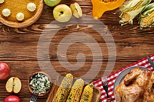 Top view of roasted turkey, pumpkin pie and grilled vegetables served on wooden table.