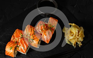 Top view of Roll with salmon on a plate of slate, near wasabi and ginger