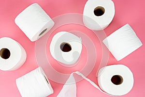 Top view of rolls of toilet paper on pink background