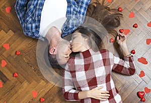 Top view of romantic couple lying on floor, expressing love to soul mate