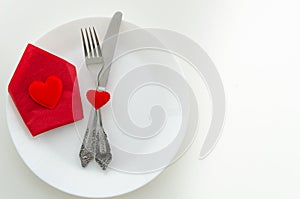 Top view romantic dinner proposal concept. Dish with cutlery and red gift box with heart. Copy space for lettering or