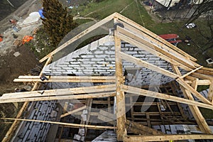 Top view of roof frame from wooden lumber beams and planks on walls made of hollow foam insulation blocks. Building, roofing,