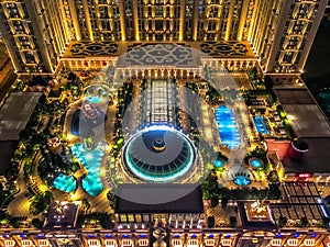 Top view of the roof garden of hotel Parisian in Macau. Night illumination of swimming pool