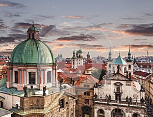 Top view of the roofs of Prague, with red tiled roofs and statues, spires and towers protruding, Czech Republic