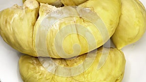 Top view rotation of peeled durian in white ceramic plate.