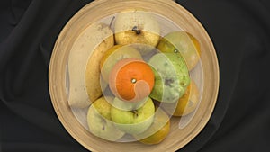 Top view rotation of various tropical fruit in bamboo tray.