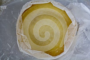 Top view of round cheese wrapped in cheesecloth