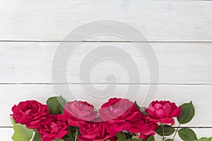 Top view of row of red roses on white wooden background, lots of copyspace. Greetimgs with valintines day, photo