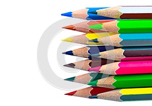Top view of row of various colored wood pencil crayons placed on top of another