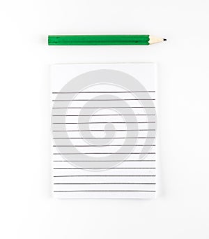 Top view of Ruled paper notepad with green pencil on white background Leave space for adding your content