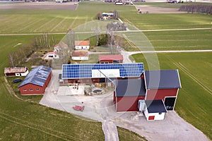 Top view of rural landscape on sunny spring day. Farm with solar photo voltaic panels system on wooden building, barn or house photo