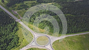 Top view of rural roundabout. Clip. Traffic on roundabout rural road in wooded area