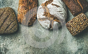 Top view of rustic bread loaves over grey background