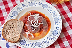 Top view on rustic plate with  typical czech pub snack, roasted sausages in beer sauce