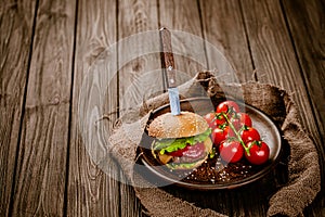 Top view of rustic serving appetite beef burger with knife on wooden table. gastro pub