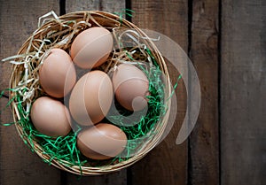 Top view rustic style eggs in basket on wooden background with copy space