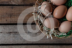 Top view rustic style eggs in basket on wooden background with copy space