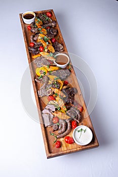 Top view Rustic wooden platter with assorted meats and vegetables