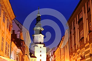 Pohled shora na Saint Michael Gate a sousední domy večer v Bratislavě, Slovensko
