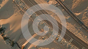 Top view sand road over summer dunes nature. Aerial asphalt highway stretching