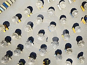 Top view on sandy beach with colorful sunbeds and parasols