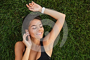 Top view of a satisfied fitness girl in earphones laying photo