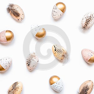 Top view of scattered Easter eggs colored with golden paint in different patterns. White background