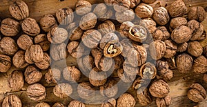 Top view scattered walnuts nut on wooden background close up