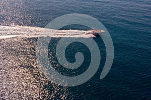 Top view of the sea and a high-speed white boat on a Sunny day.