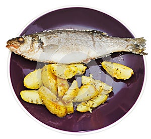 Top view of seabass and fried potatoes in plate