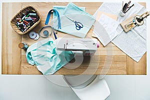 top view of seamstress workplace with fabric, sewing machine, drafts