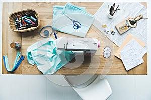 top view of seamstress workplace with fabric, sewing machine, drafts