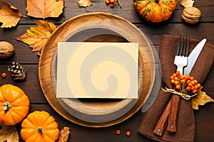 Top view of seasonal table setting with pumpkins and autumn leaves on wooden background. Thanksgiving Day