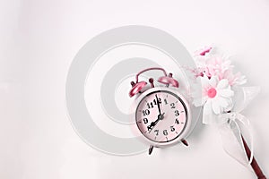 Top view selective focus vintage alarm clock  with beautiful bouquet flowers  on white background. Love anniversary, dating and