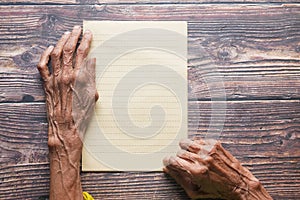top view of senior woman hand on blank paper on table