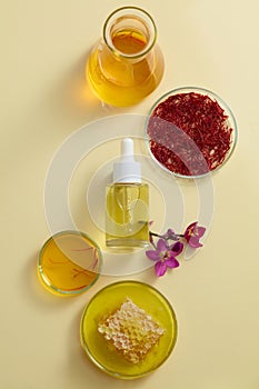 Top view of a serum bottle unbranded displayed on beige background with fresh ingredient