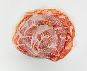Top view of a serving of dry coppa on a white plate