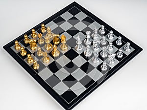 Top view of set of golden and silver chess pieces element, king, queen rook, bishop, knight, pawn standing on chessboard.