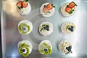 Top-view set of sweet airy meringue nests with swirls of cream