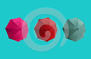 Top view, Set three colours umbrella isolated on cyan background, stock photo, invesment, business, summer concept, red pink dark