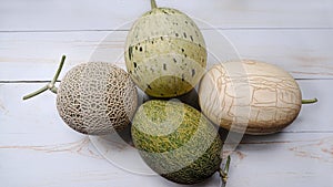 top view of several types of melons on a white wooden table