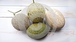 top view of several types of melons on a white wooden table